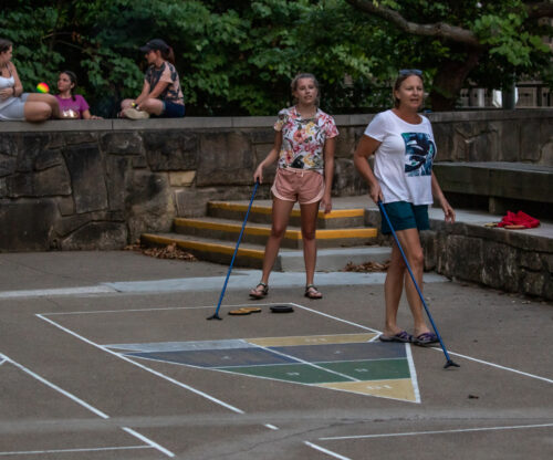 a family plays shuffleboard at the mochican lodge