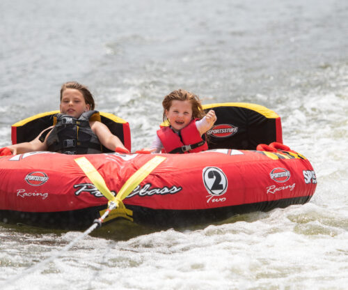 kids scream with delight while tubing on the lake at salt fork